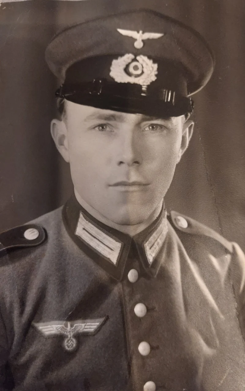 Porträt eines jungen Mannes in Uniform mit Schirmmütze.