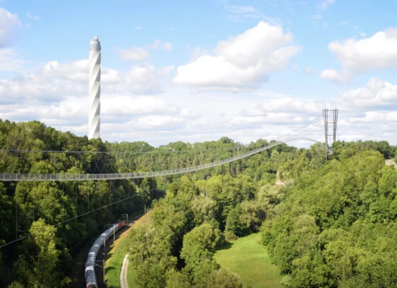 Lange Hängebrücke über das bewaldete Neckartal, im Hintergrund der weiße, gedrehte Testturm.
